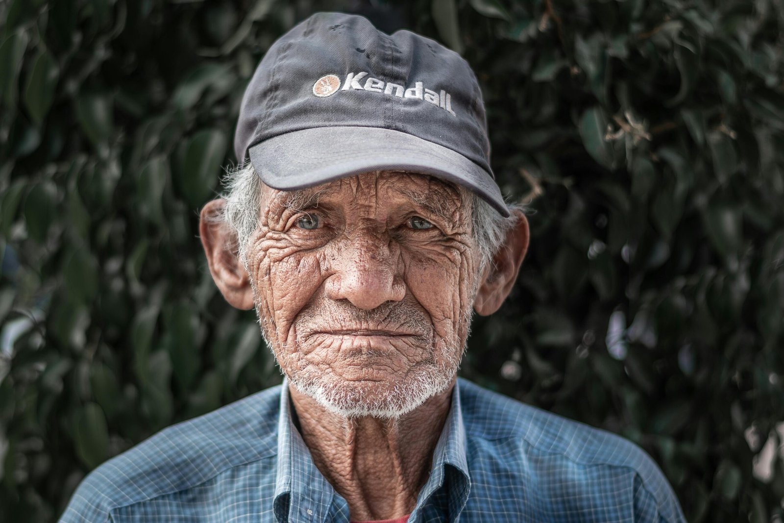 Portrait Photo of Elderly Man in Blue Collared Shirt and Black Hat